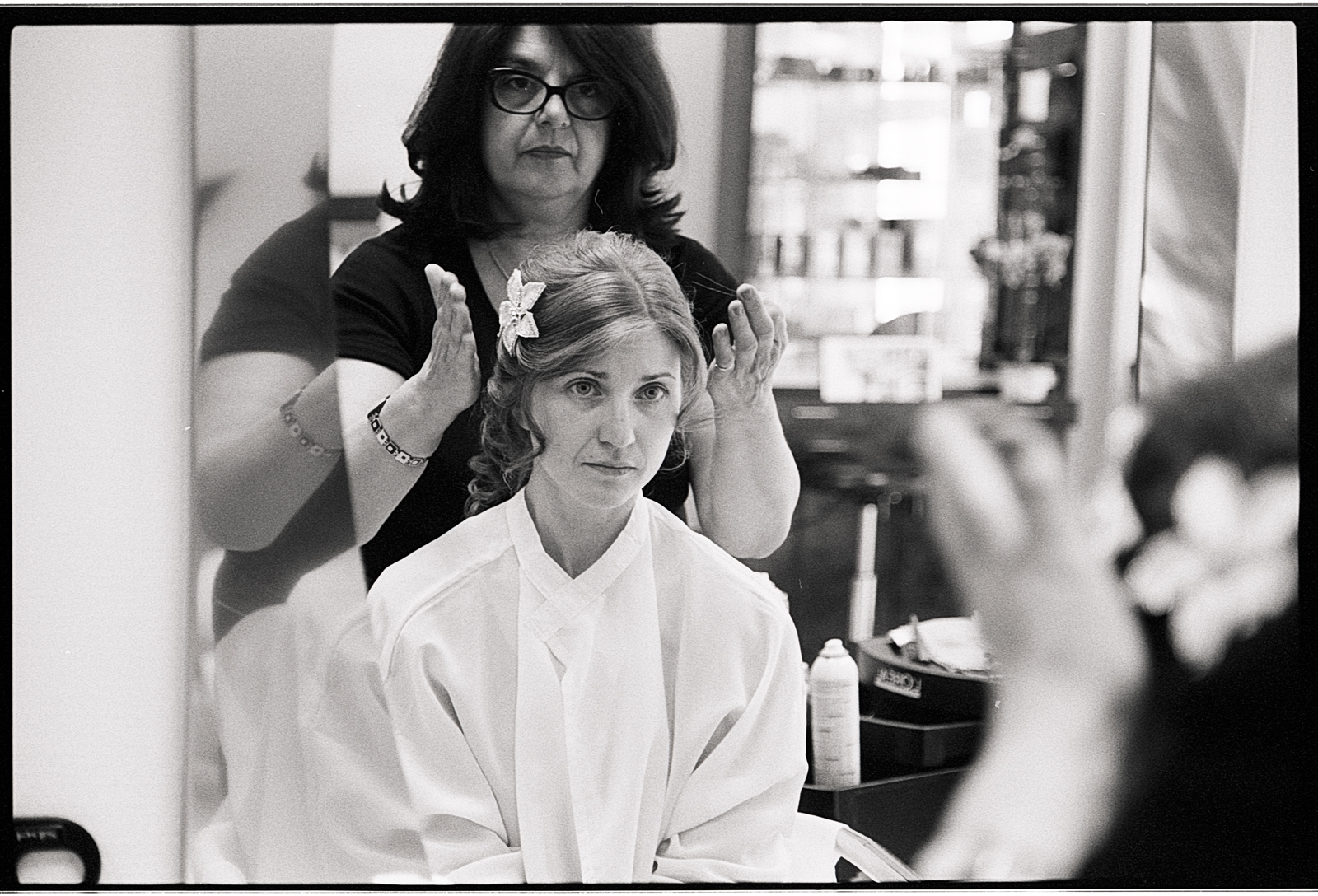 Photographie argentique des préparatifs de la mariée. reportage photo mariage en noir et blanc au salon de coiffure.
