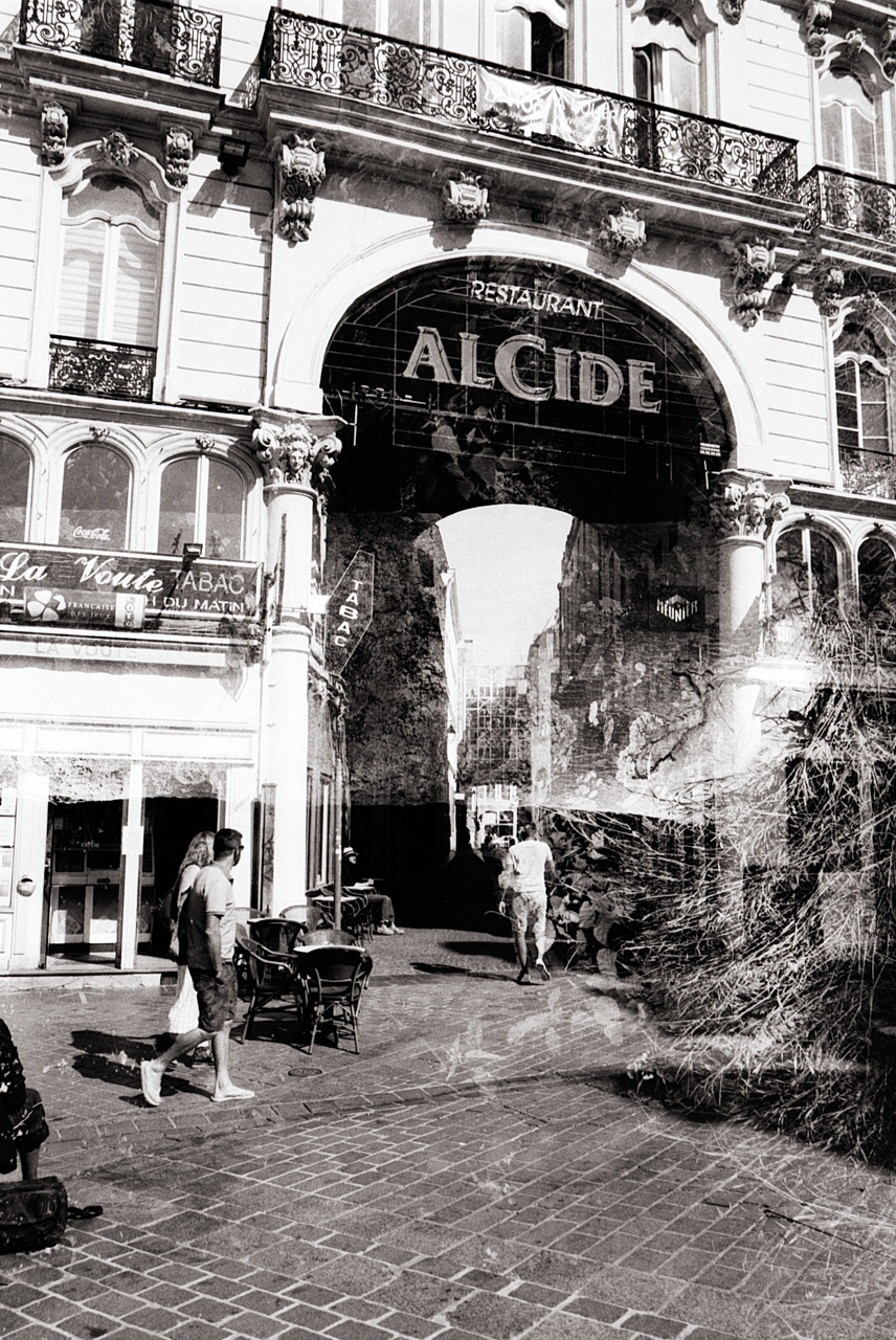 Double exposition de rue dans un contexte urbain noir et blanc, mettant en évidence des bâtiments historiques et des passants à Lille.