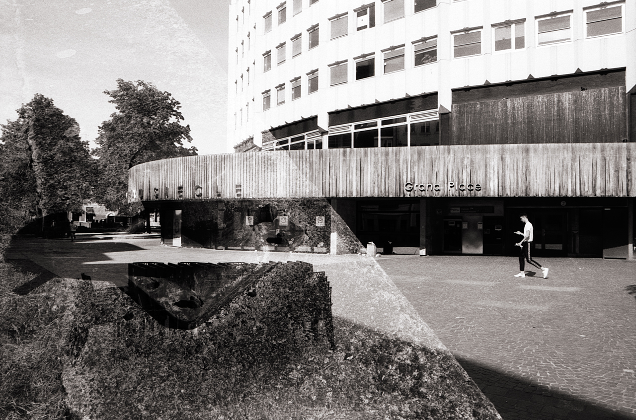 Double exposition en noir et blanc montrant un bâtiment avec un panneau en bois et une personne marchant devant, le tout fusionné avec une texture de paysage urbain.