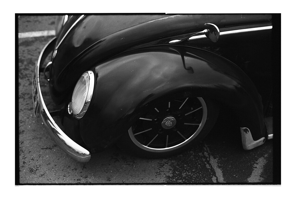 Capot d'une Coccinelle customisée noire. Photographie argentique noir et blanc sur les matières.