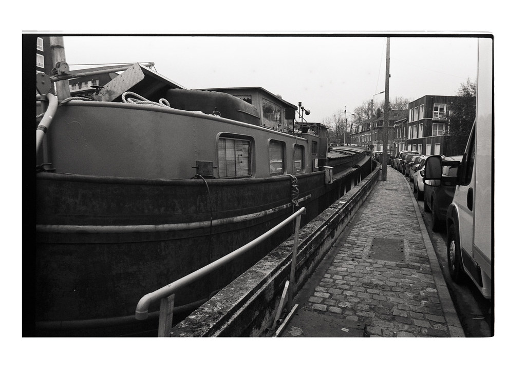 Péniche à quai sur le canal de Lomme. photographie argentique noir et blanc. Cours photo individuel et en groupes. Sorties thématiques apprendre à photographier en argentique avec un reflex.