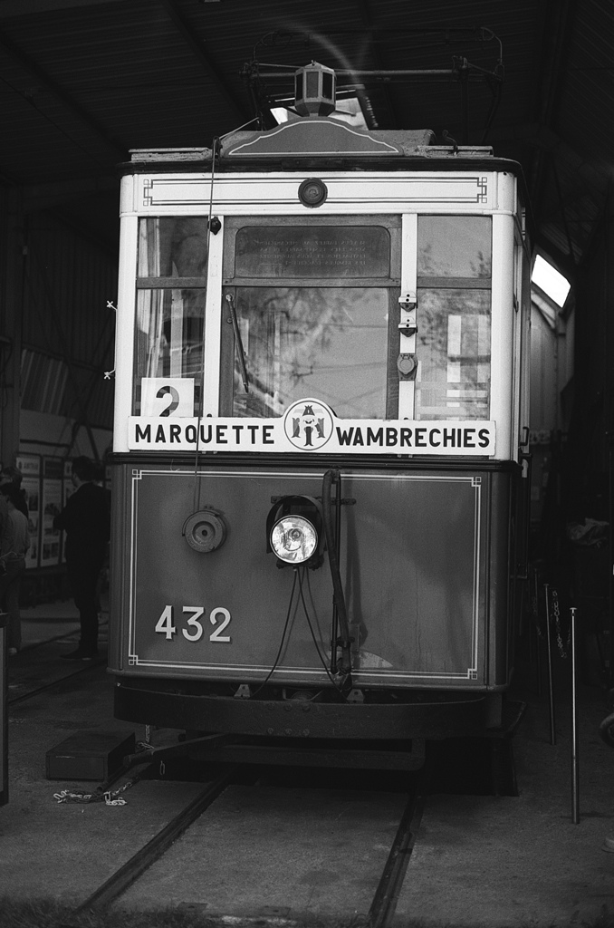 Tramway ancien en noir et blanc, numéroté 432, stationné dans un garage avec les destinations 'Marquette' et 'Wambrechies' affichées à l'avant.