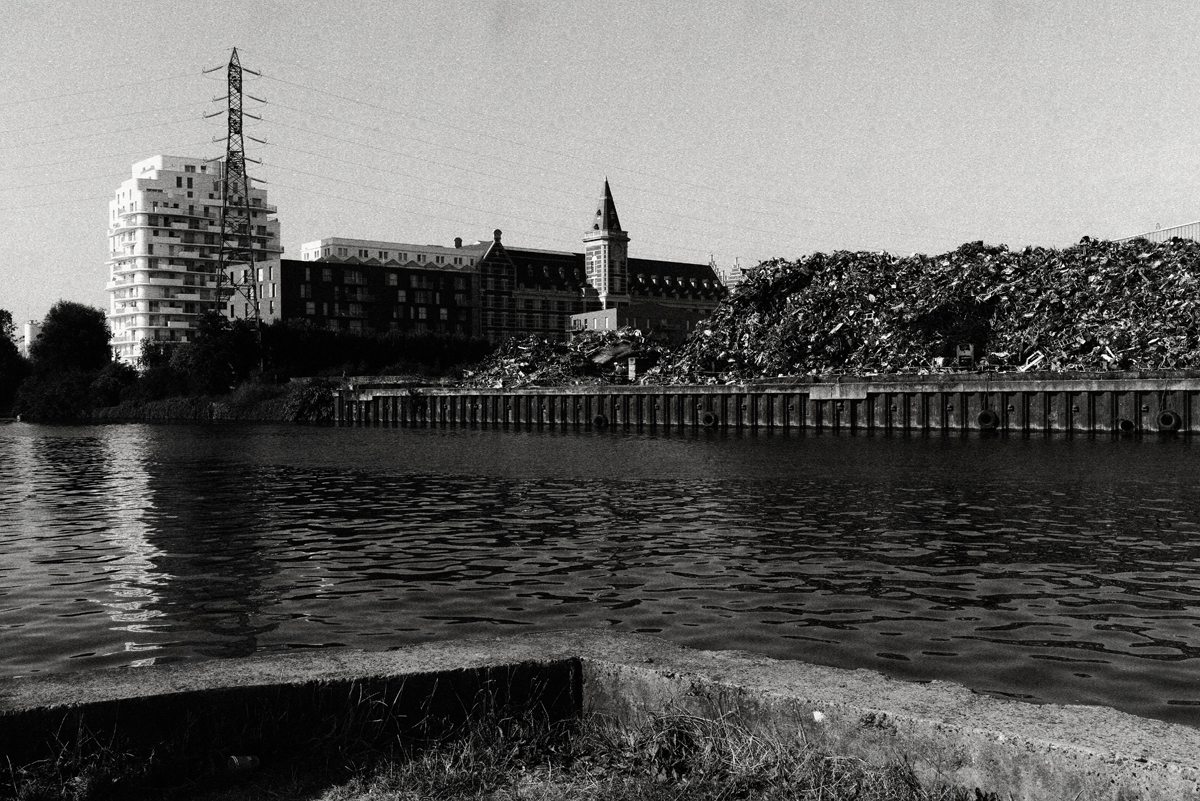 Photographie argentique en noir et blanc du canal de la Deûle à Lille. L'ancien et le moderne se mélangent à l'industriel.