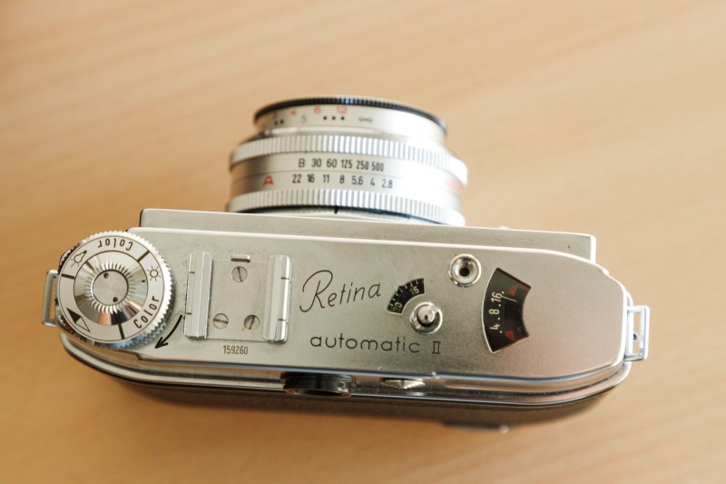Vue du dessus d'un appareil photo vintage Kodak Retina Automatic II, mettant en évidence le cadran et les réglages de l'objectif.