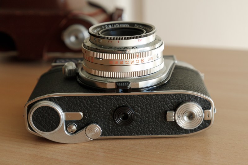 Vue en gros plan d'un appareil photo vintage Kodak Retina Automatic II posé sur une surface en bois.