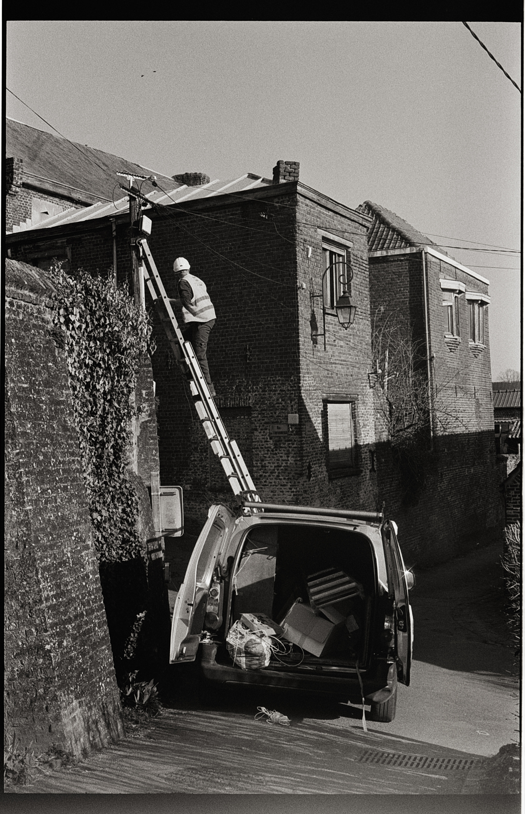 Photo argentique noir et blanc d'une ruelle pavée à Cassel, ambiance rétro à la Doisneau.